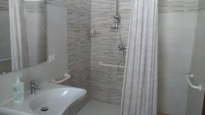 a white bathroom with a sink and a shower at Agriturismo Grisciano in Accumoli