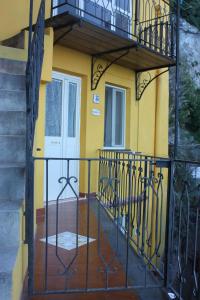 a yellow house with a balcony and a door at Casa Reginella - Borgo Marinaro in Conca dei Marini