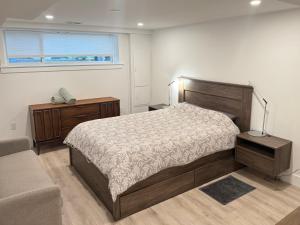 a bedroom with a bed and a couch and a window at The Orange Door Bungalow- 2-BR w private yard, walkable to cafes & restaurants, 10 min to DT in Vancouver