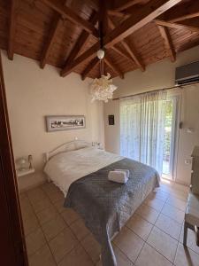 a bedroom with a bed and a chandelier at Villa Trifylli in Mesimvría