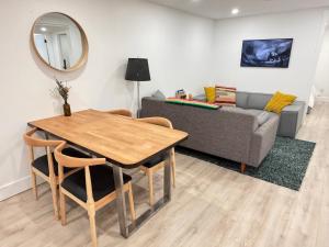 a living room with a table and a couch at The Orange Door Bungalow- 2-BR w private yard, walkable to cafes & restaurants, 10 min to DT in Vancouver