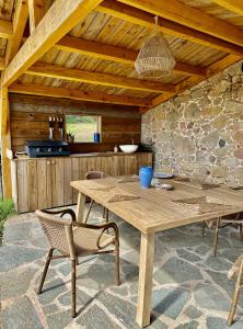 a wooden table and chairs in an outdoor kitchen at BERGERIE PARADISU, Domaine de l Ogliastru in Olmeto