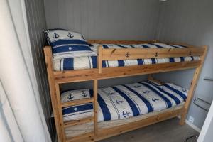 two bunk beds with blue and white sheets and pillows at Oslofjord Sea View in Hvitsten