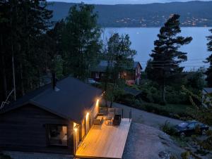 a house with a deck at night with lights at Oslofjord Sea View in Hvitsten