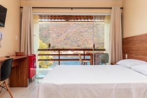 a bedroom with a bed and a large window at Pousada Porto de Piranhas in Piranhas