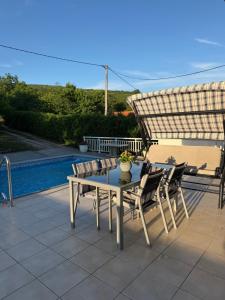 a table and chairs on a patio with an umbrella at Apartmani Novak in Mostar