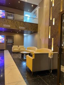 a lobby with chairs and tables in a building at Bs BnB Luxury Studio Apartment in Dehradun