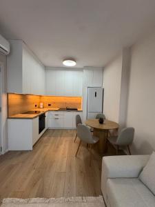a living room with a kitchen and a table and a couch at Dio East Apartments in Tirana