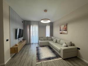 a living room with a couch and a tv at Dio East Apartments in Tirana