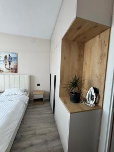 a bedroom with a bed and a desk with a plant at Dio East Apartments in Tirana