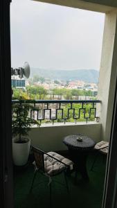 a balcony with a table and chairs and a view at Bs BnB Luxury Studio Apartment in Dehradun