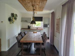a kitchen and dining room with a wooden table and chairs at Oevr652 in Earnewâld