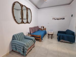 a living room with two blue couches and a mirror at Isthmus Filoxenia in Isthmia