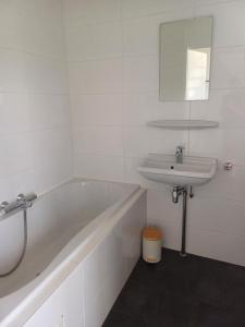 a white bathroom with a tub and a sink at Oevr652 in Earnewâld +14 photos