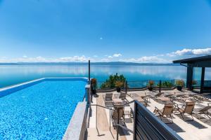 a swimming pool with chairs and a view of the water at Boutique Hotel Nika in Ohrid