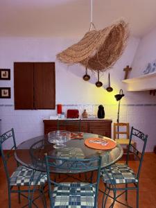 a kitchen with a glass table and chairs in a room at MONTE DA ADEGA in Vale de Água