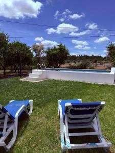 two lounge chairs sitting on the grass near a swimming pool at MONTE DA ADEGA in Vale de Água