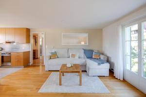 a living room with a white couch and a table at Trois Lacs Suites in Erlach