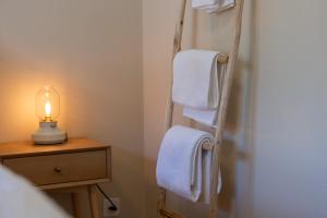 a bathroom with a towel rack with white towels at Trois Lacs Suites in Erlach +17 photos