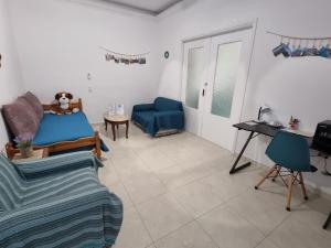 a living room with a blue bed and a couch at Isthmus Filoxenia in Isthmia