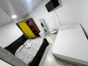 a small bedroom with a bed and a phone at Miss Titi's Native Lodge in San Andrés