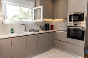 a kitchen with white cabinets and a window at Aroma Zia Residences in Lagoúdi Zía +31 photos
