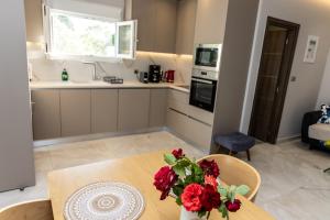 a kitchen with a table with red flowers on it at Aroma Zia Residences in Lagoúdi Zía