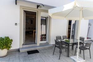a patio with a table and chairs and an umbrella at Aroma Zia Residences in Lagoúdi Zía