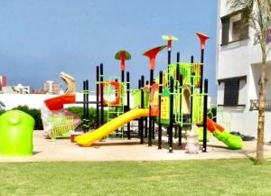 a playground with a slide in a park at Chic apartment with secure pool in Oued Laou