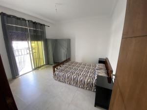 a bedroom with a bed and a large window at Chic apartment with secure pool in Oued Laou +1 photo