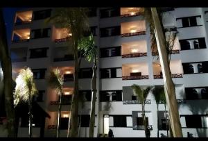 a tall building with palm trees in front of it at Chic apartment with secure pool in Oued Laou