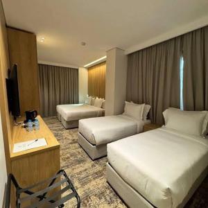 a hotel room with two beds and a television at Beach hostel in Marsa Alam City