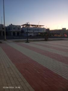 a parking lot with a building and a street light at Beach hostel in Marsa Alam City +1 photo