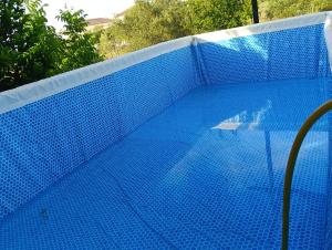 a blue swimming pool with a blue fence at Casita del Romero Ronda in Ronda