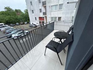 a balcony with a chair and a parking lot at Hij Apartaments in Rădăuţi