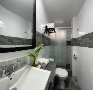 a bathroom with a sink and a toilet and a mirror at Hotel Machupicchu Adventure in Machu Picchu +63 photos
