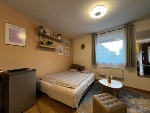 a bedroom with a bed and a table and a window at Puzzle Haus in Gyenesdiás