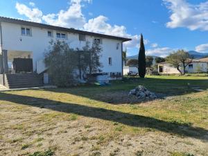 a large white house with a large yard at Comfortable apartment with mountain views in Ghisonaccia