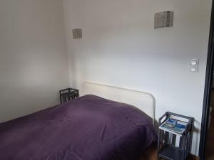 a bedroom with a bed with a purple blanket at Comfortable apartment with mountain views in Ghisonaccia