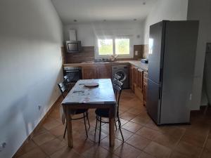 a kitchen with a table and a refrigerator at Comfortable apartment with mountain views in Ghisonaccia