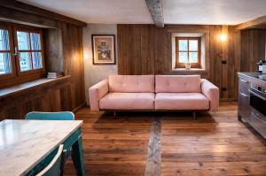 a living room with a pink couch in a kitchen at Casalpina Cozy chalet in Gressoney-la-Trinité