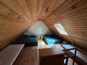 an attic room with two beds and a wooden ceiling at Gąsiorówka in Gryżyna