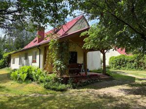 a small white house with a red roof at Gąsiorówka in Gryżyna