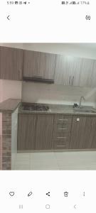 a kitchen with wooden cabinets and a counter top at Lindo apartamento Girón in Girón