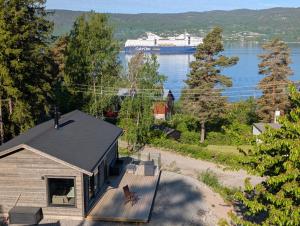 a house with a large cruise ship in the water at Oslofjord Sea View in Hvitsten +14 photos