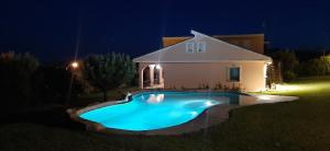 a swimming pool in front of a house at night at Finca SOTOMAR-casa rural Simancas in Simancas
