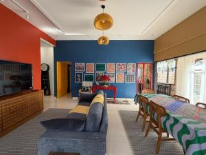 a living room with blue and orange walls and a couch at Tamu Beradu Seaview Private Pool Villa in Dungun