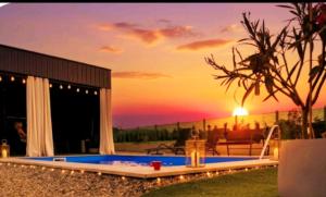 a pool with a sunset in the background at Green Nest in Laktaši