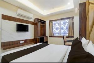 a bedroom with a bed and a tv and a window at Cross Lane- A Boutique Hotel-Kota in Kota