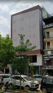 a tall building with cars parked in a parking lot at Cross Lane- A Boutique Hotel-Kota in Kota